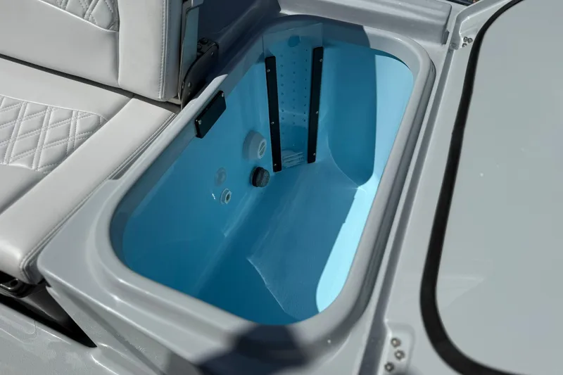 Slide: The Image of Livewell compartment in 2026 Crevalle 26 HCO boat, featuring light blue interior. - 22