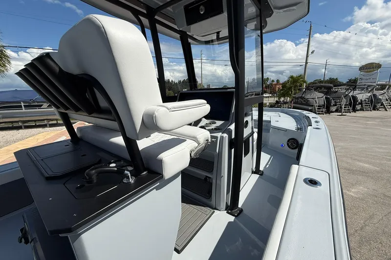 Slide: The Image of 2026 Crevalle 26 HCO boat interior with helm and seating, under a clear blue sky. - 29