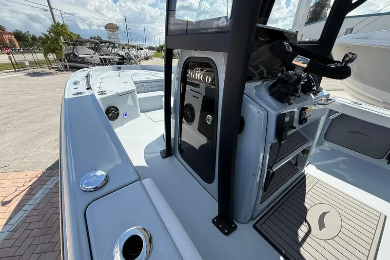 Slide: The Image of 2026 Crevalle 26 HCO boat interior with console and seating, displayed outdoors. - 34