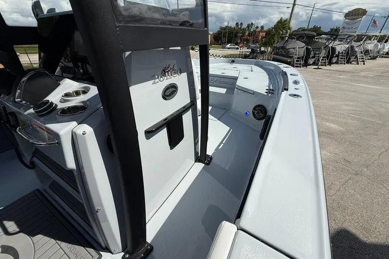 Slide: The Image of 2026 Crevalle 26 HCO boat interior with console and seating, parked outdoors. - 35