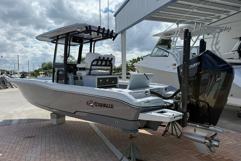 Slide: The Image of 2026 Crevalle 26 HCO boat with Mercury engine, docked outdoors under cloudy sky. - 4