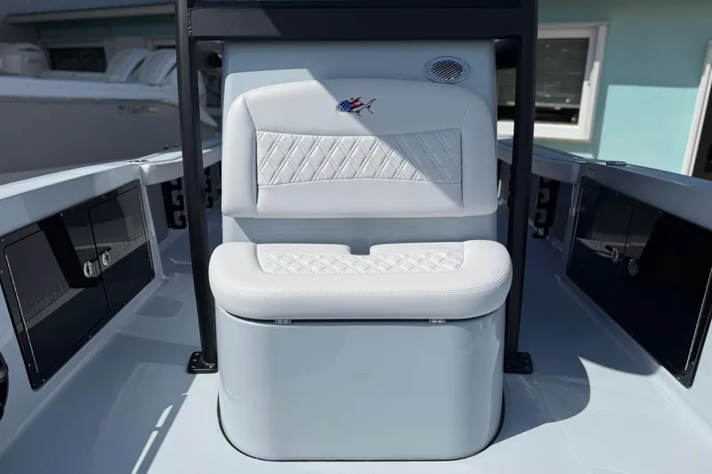 Slide: The Image of 2026 Crevalle 26 HCO boat interior with white cushioned seating and storage compartments. - 59