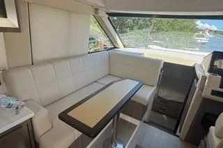 Slide: The Image of 2021 Regal 38 XO yacht interior with white seating and table, featuring large windows. - 33