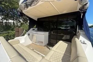 Slide: The Image of 2021 Regal 38 XO yacht cruising through a scenic waterway with lush greenery. - 34