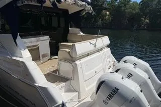 Slide: The Image of 2021 Regal 38 XO boat with triple outboard engines docked by a serene waterway. - 37