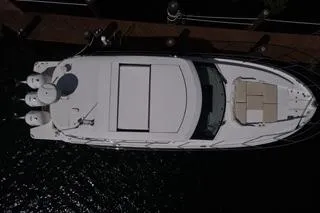 Slide: The Image of 2021 Regal 38 XO boat with triple outboard engines docked by a scenic waterway. - 4