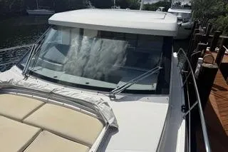 Slide: The Image of 2021 Regal 38 XO yacht docked on a serene waterway. - 51