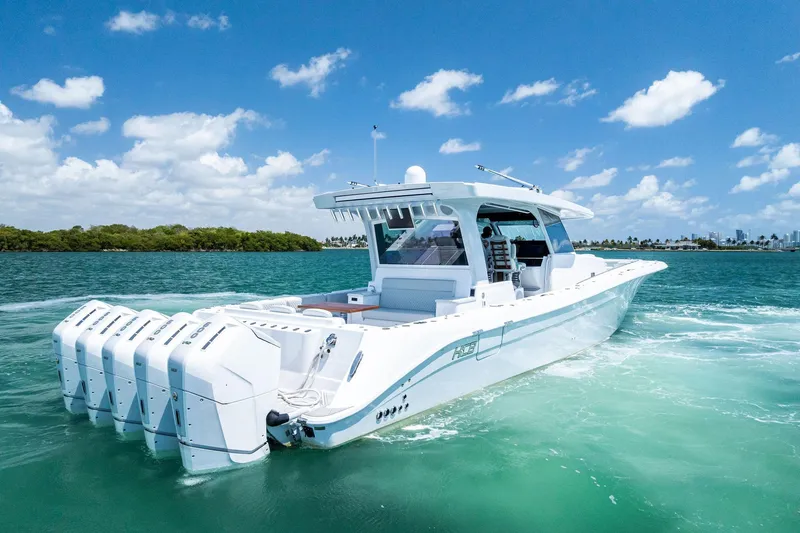 Slide: The Image of 2025 HCB 56 Suenos GIX luxury boat cruising on clear blue water. - 11