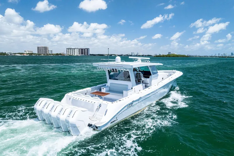 Slide: The Image of 2025 HCB 56 Suenos GIX luxury boat cruising on open water under a clear blue sky. - 13
