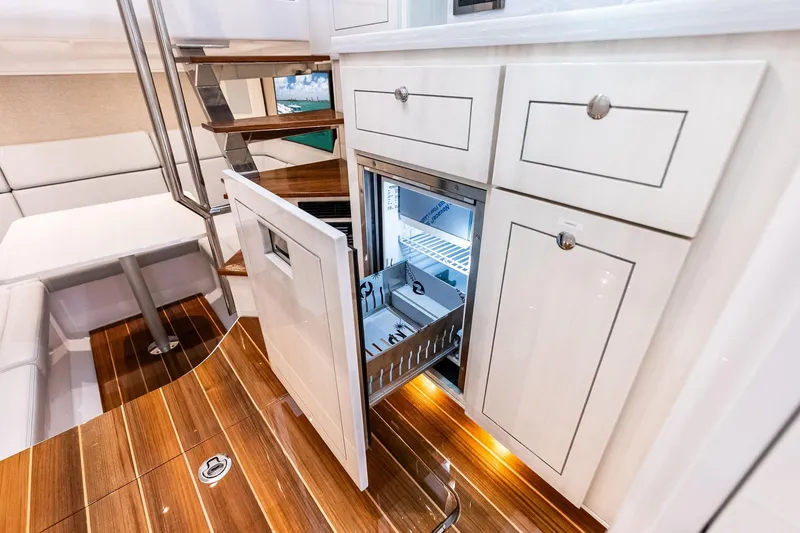 Slide: The Image of Luxurious interior of 2025 HCB 56 Suenos GIX yacht with open fridge and elegant wood flooring. - 26