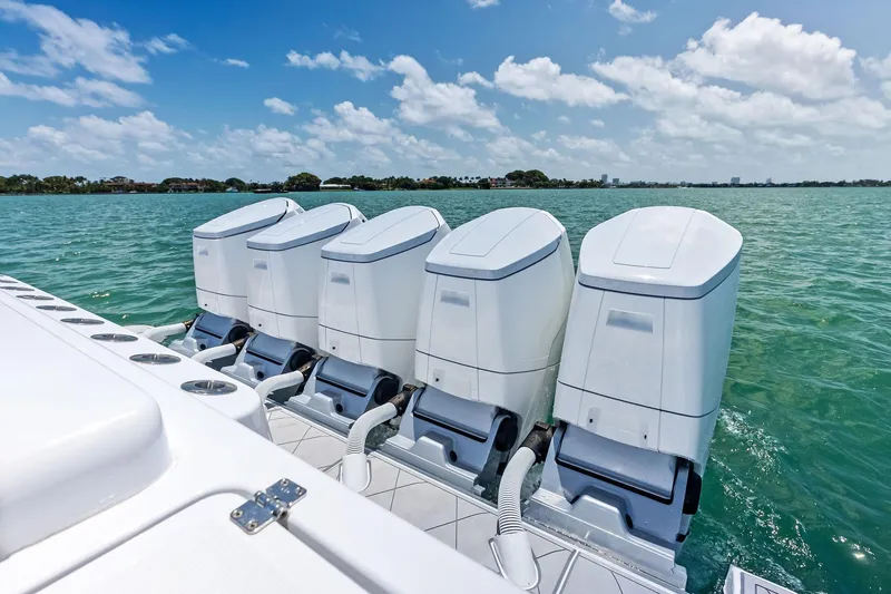 Slide: The Image of Four powerful outboard engines on a 2025 HCB 56 Suenos GIX boat in clear waters. - 58