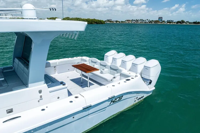 Slide: The Image of 2025 HCB 56 Suenos GIX luxury boat on clear blue water, featuring multiple engines. - 6