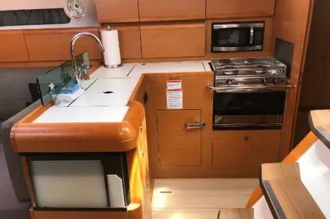 Slide: The Image of 2016 Jeanneau Sun Odyssey 419 yacht kitchen with stove, sink, and microwave. - 8