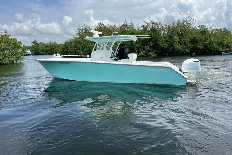 Slide: The Image of 2018 SeaHunter 31 Tournament boat on calm water, surrounded by lush greenery. - 3