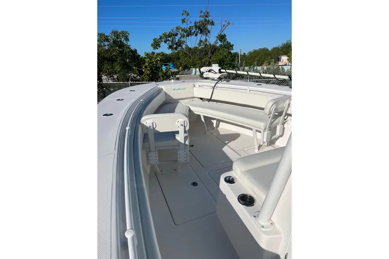 Slide: The Image of 2018 SeaHunter 31 Tournament boat interior with seating and cup holders, under clear blue sky. - 4