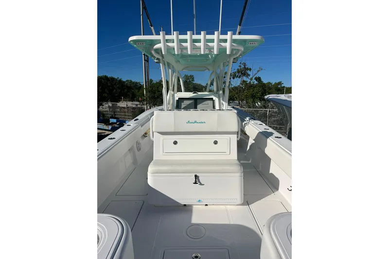 Slide: The Image of 2018 SeaHunter 31 Tournament boat interior with seating and storage, under clear blue sky. - 9