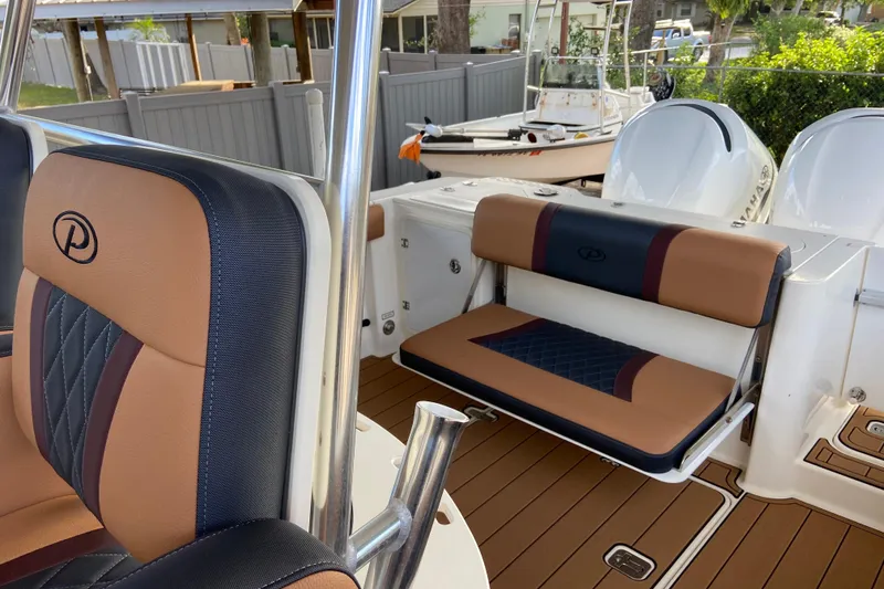 Slide: The Image of 2010 Pursuit C 280 Center Console boat with sleek red hull against clear blue sky. - 10