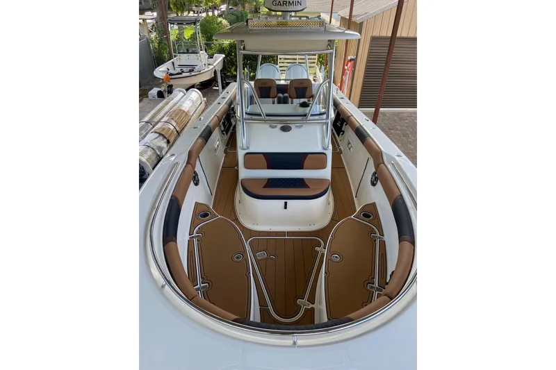 Slide: The Image of 2010 Pursuit C 280 Center Console boat with glossy red hull in a marina setting. - 12