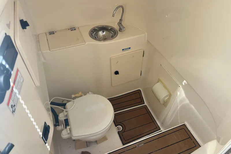 Slide: The Image of 2010 Pursuit C 280 Center Console boat bathroom with sink and toilet. - 19