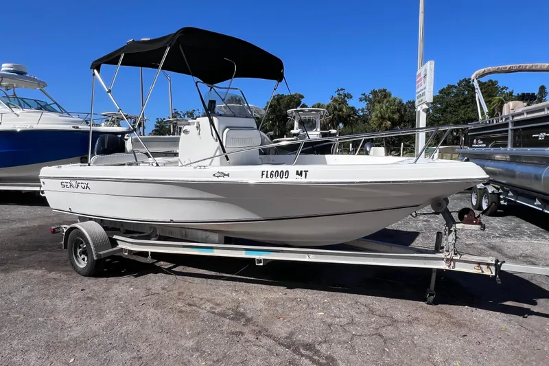 Slide: The Image of 2005 Sea Fox 197 Center Console boat on trailer, parked outdoors under clear blue sky. - 11