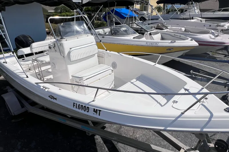 Slide: The Image of 2005 Sea Fox 197 Center Console boat on trailer, white exterior, parked among other boats. - 12