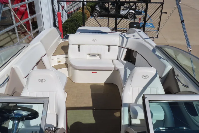 Slide: The Image of 2005 Cobalt 272 boat interior with white seating and steering wheel, docked outdoors. - 20