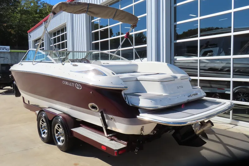 Slide: The Image of 2005 Cobalt 272 boat on trailer, parked outside a modern building. - 4