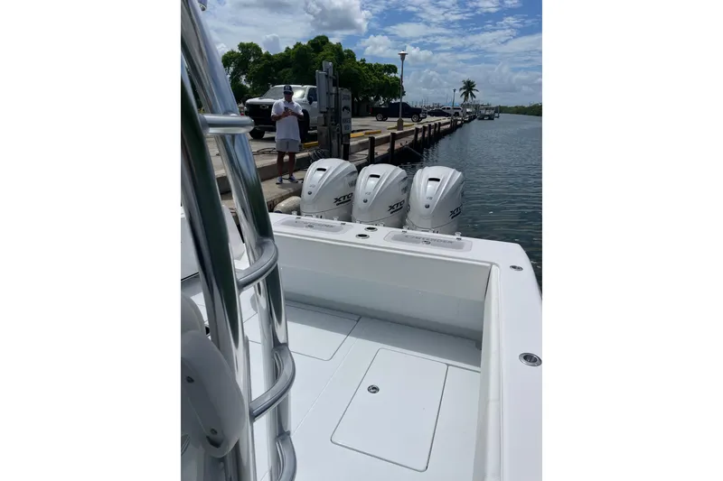 Slide: The Image of 2025 Contender 44 ST boat with powerful outboard engines docked by the water. - 3