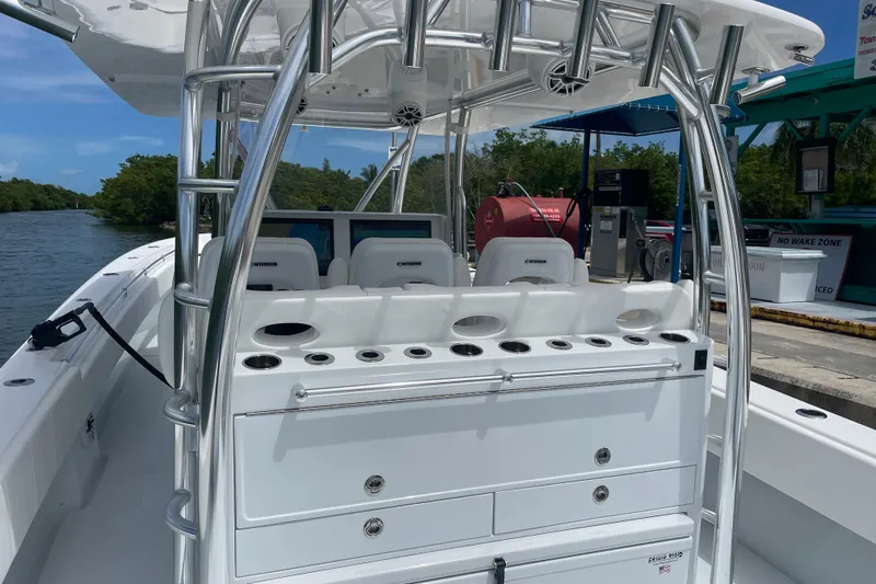 Slide: The Image of 2025 Contender 44 ST boat interior with rod holders and seating at a dock. - 4