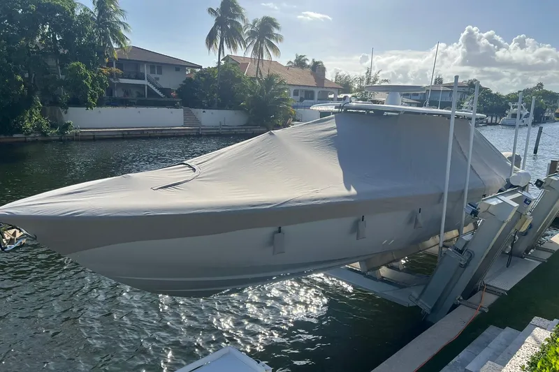 Slide: The Image of 2025 Contender 44 ST boat covered and docked by a scenic waterfront. - 9