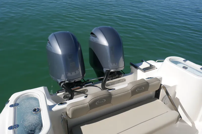 Slide: The Image of 2021 Key West 244 Center Console boat with dual outboard motors on calm water. - 16