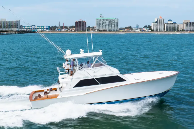 Slide: The Image of 1972 Jim Smith Custom Convertible yacht cruising near a coastal city skyline. - 4