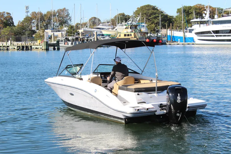 Slide: The Image of 2023 Sea Ray SPX 210 boat cruising in a marina with a Mercury 150 outboard engine. - 4