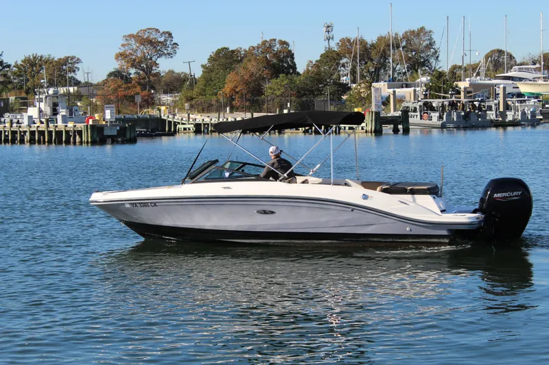 Slide: The Image of 2023 Sea Ray SPX 210 boat cruising on a calm waterway with scenic background. - 6