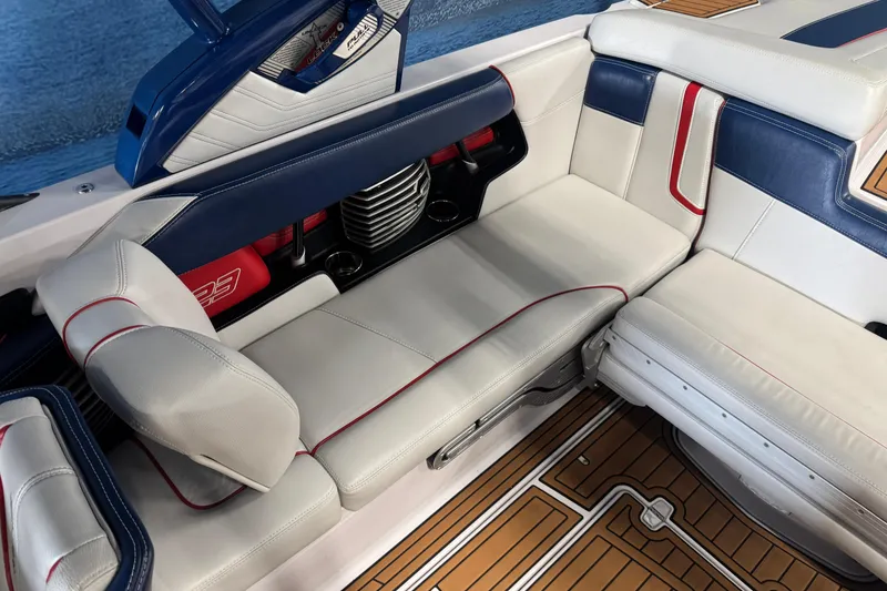 Slide: The Image of 2015 Nautique Super Air Nautique G23 interior with white and blue seating, red accents, and teak flooring. - 8