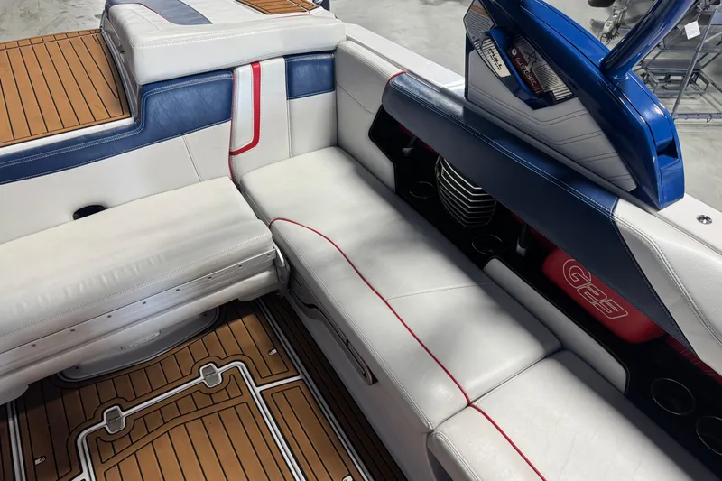 Slide: The Image of 2015 Nautique Super Air Nautique G23 interior with white and blue seating, teak flooring. - 9