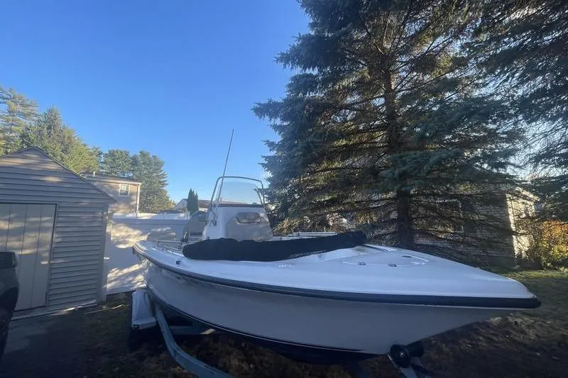 Slide: The Image of 2023 Key West 189 FS boat on trailer, parked outdoors near trees and a shed. - 4