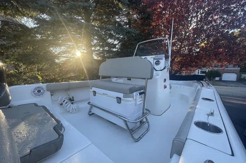 Slide: The Image of 2023 Key West 189 FS boat interior with seating and console, sunlit background. - 7