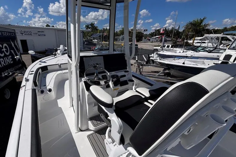 Slide: The Image of 2026 Tidewater 2300 Carolina Bay boat interior with speakers, sunny day, marina background. - 22