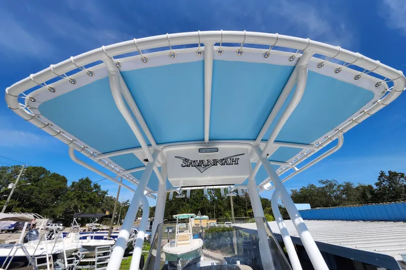 Slide: The Image of 2026 Savannah 2200 Offshore boat with blue canopy under clear sky. - 16