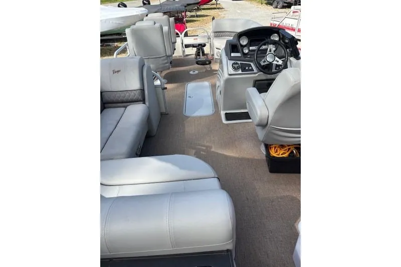 Slide: The Image of 2021 Ranger Reata 223FC boat interior with plush seating and modern dashboard. - 11