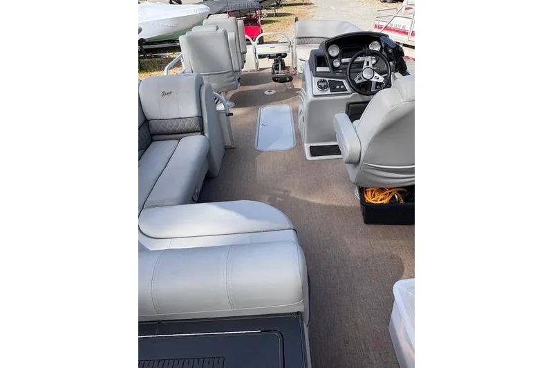 Slide: The Image of 2021 Ranger Reata 223FC boat interior with plush seating and modern dashboard. - 16