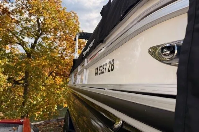 Slide: The Image of 2021 Ranger Reata 223FC boat with cover, autumn trees in background. - 2