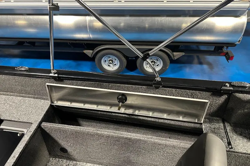 Slide: The Image of 2026 Tracker Pro Guide V-175 WT boat interior with storage compartment and trailer in background. - 13