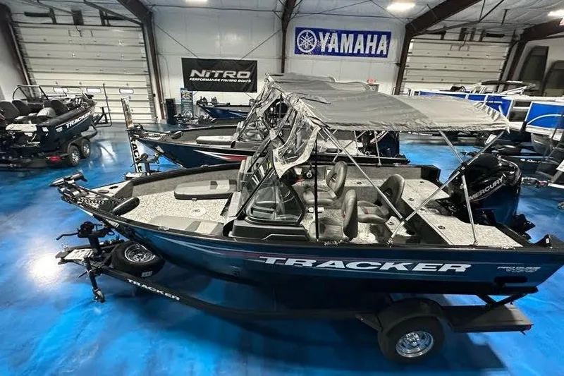 Slide: The Image of 2026 Tracker Pro Guide V-175 WT boat in showroom with canopy and Yamaha banner. - 7