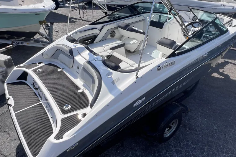 Slide: The Image of 2015 Yamaha Boats SX192, sleek design, white and black interior, parked on trailer. - 12