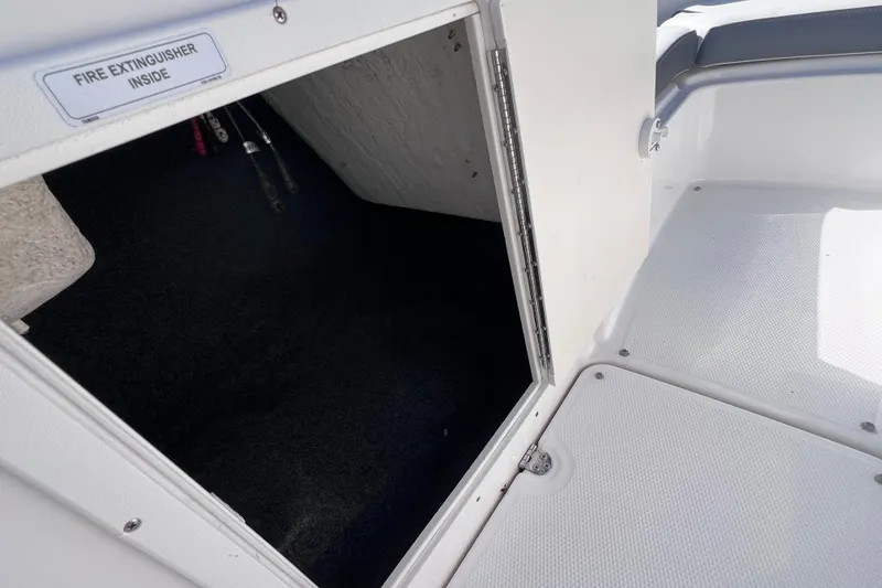 Slide: The Image of 2015 Yamaha Boats SX192 storage compartment with fire extinguisher inside, open hatch view. - 20