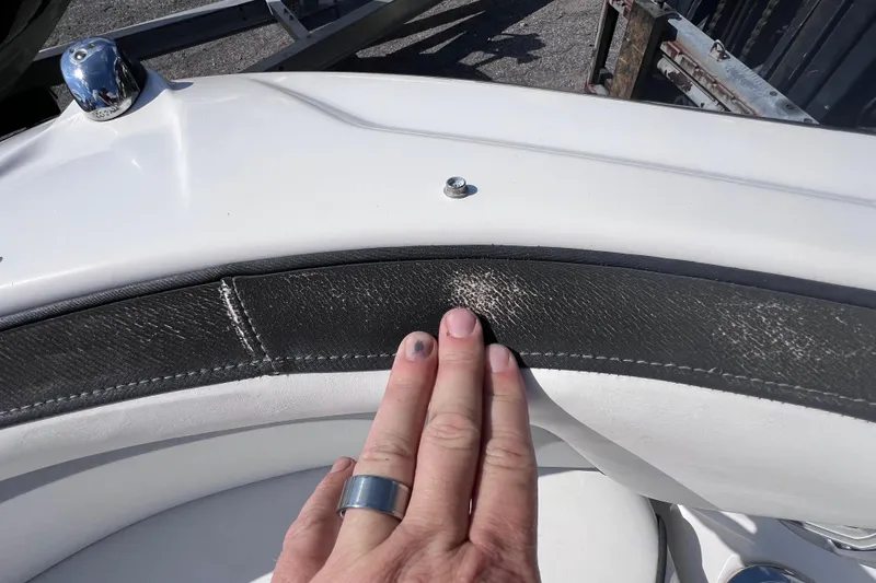 Slide: The Image of Close-up of 2015 Yamaha SX192 boat seat with visible wear and hand touching upholstery. - 23
