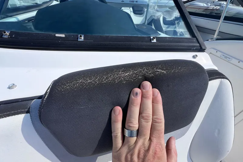 Slide: The Image of Hand touching worn upholstery on 2015 Yamaha Boats SX192 dashboard. - 24