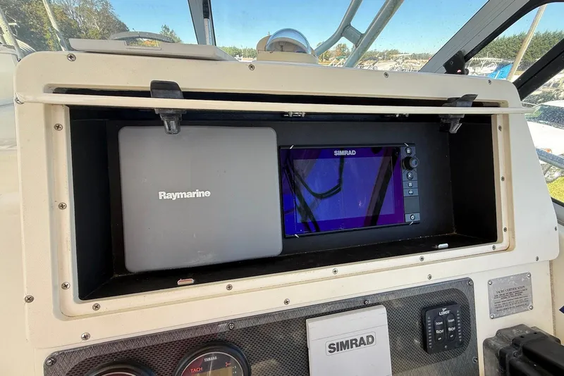 Slide: The Image of 2003 Hydra-Sports Vector 2800 WA dashboard with Raymarine and Simrad navigation systems. - 12
